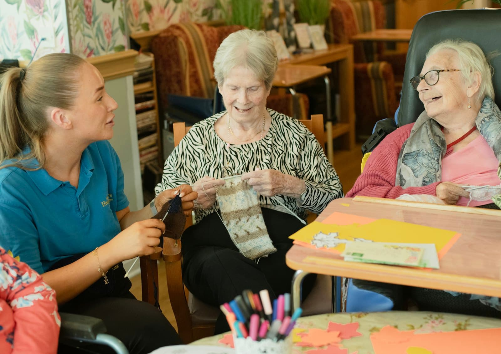 A caregiver knitting with two older women