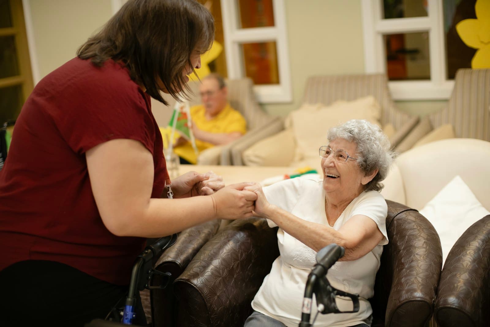 A caregiver helping an older woman walk with her walker
