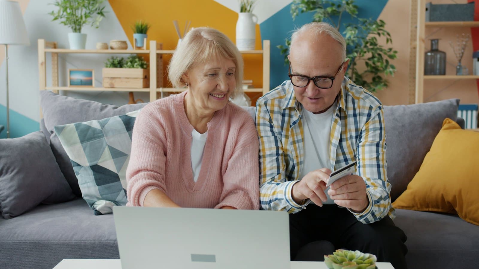 An older couple paying a bill online together