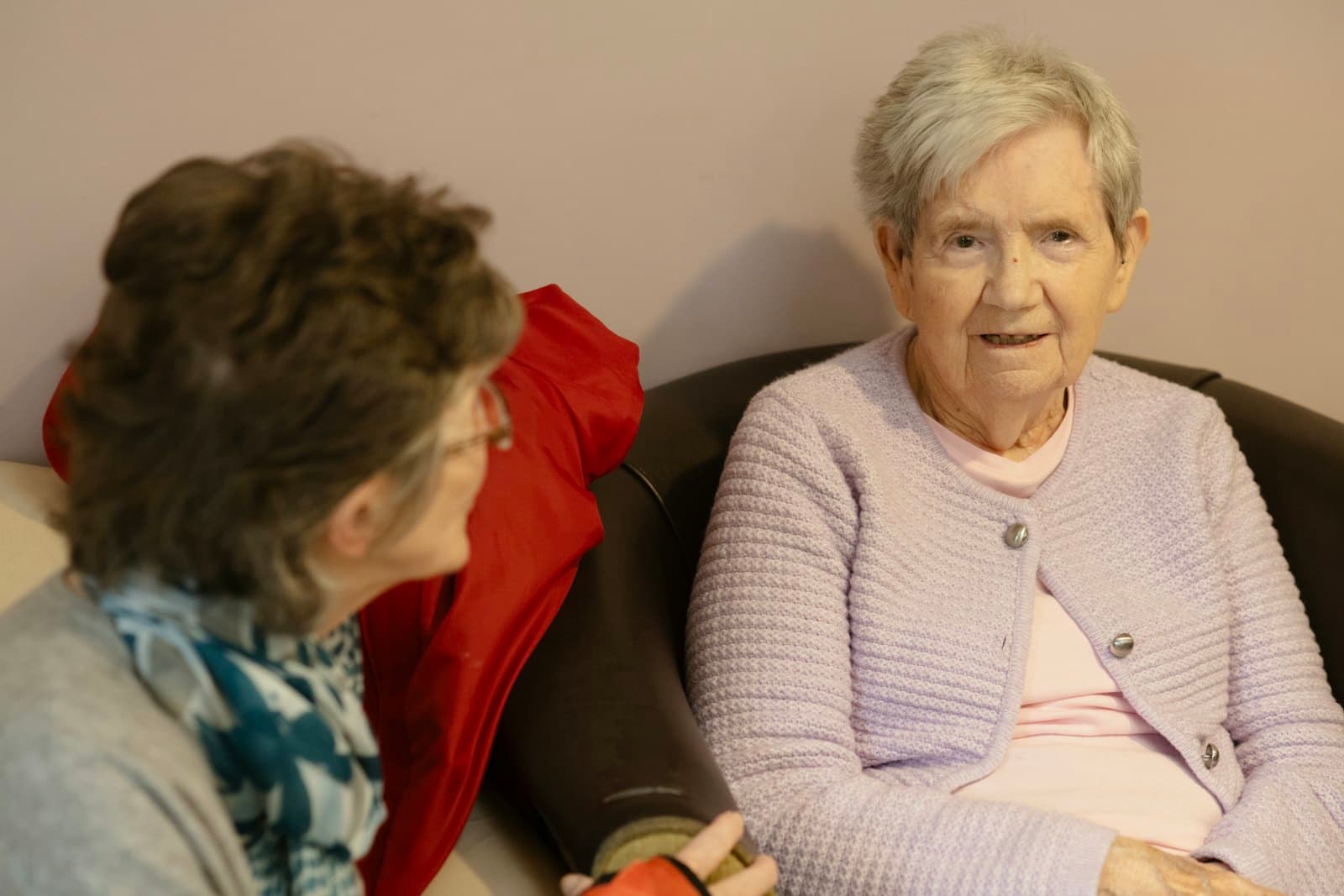 Two older women talking in comfortable armchairs