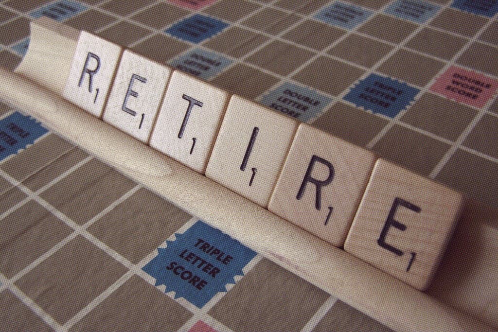Wooden letter tiles spelling RETIRE on a word game board